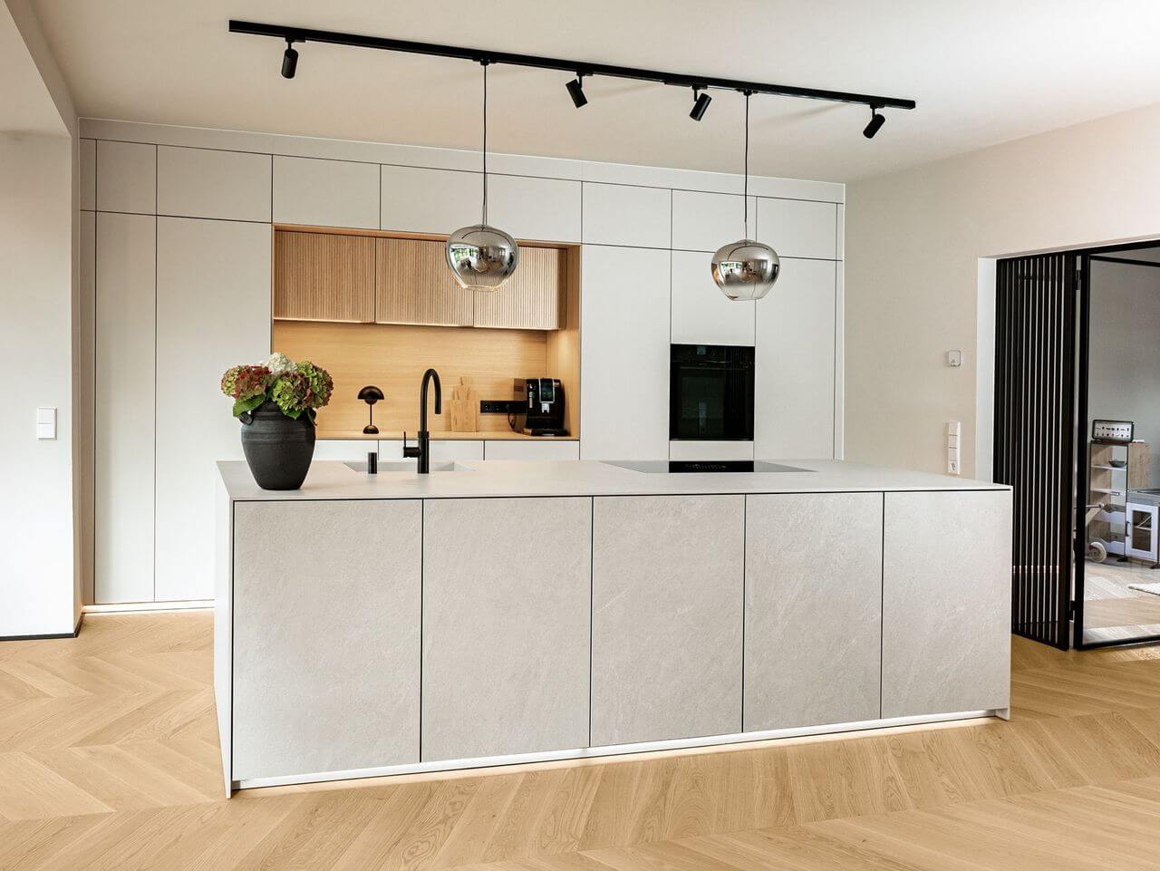 Next125-Design-Inselkueche-grau-mit-Echtholz-Rueckwand