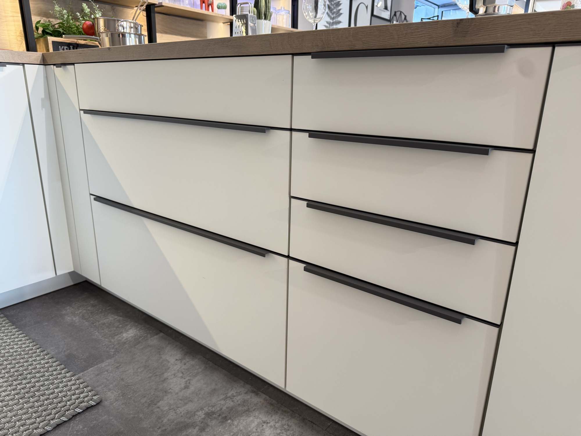 ausstellungskueche-sandbeige-schwarze-griffe-moebel-gradinger